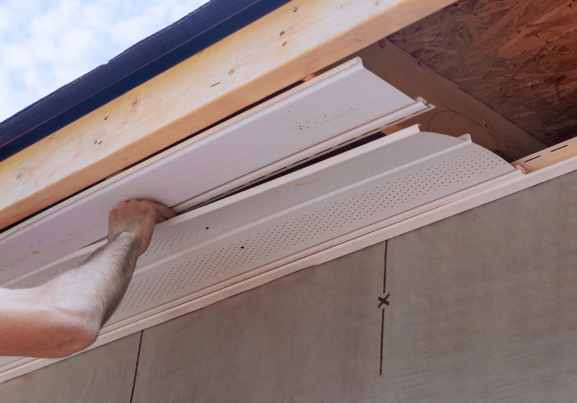 Installing new soffit siding panels on residential building