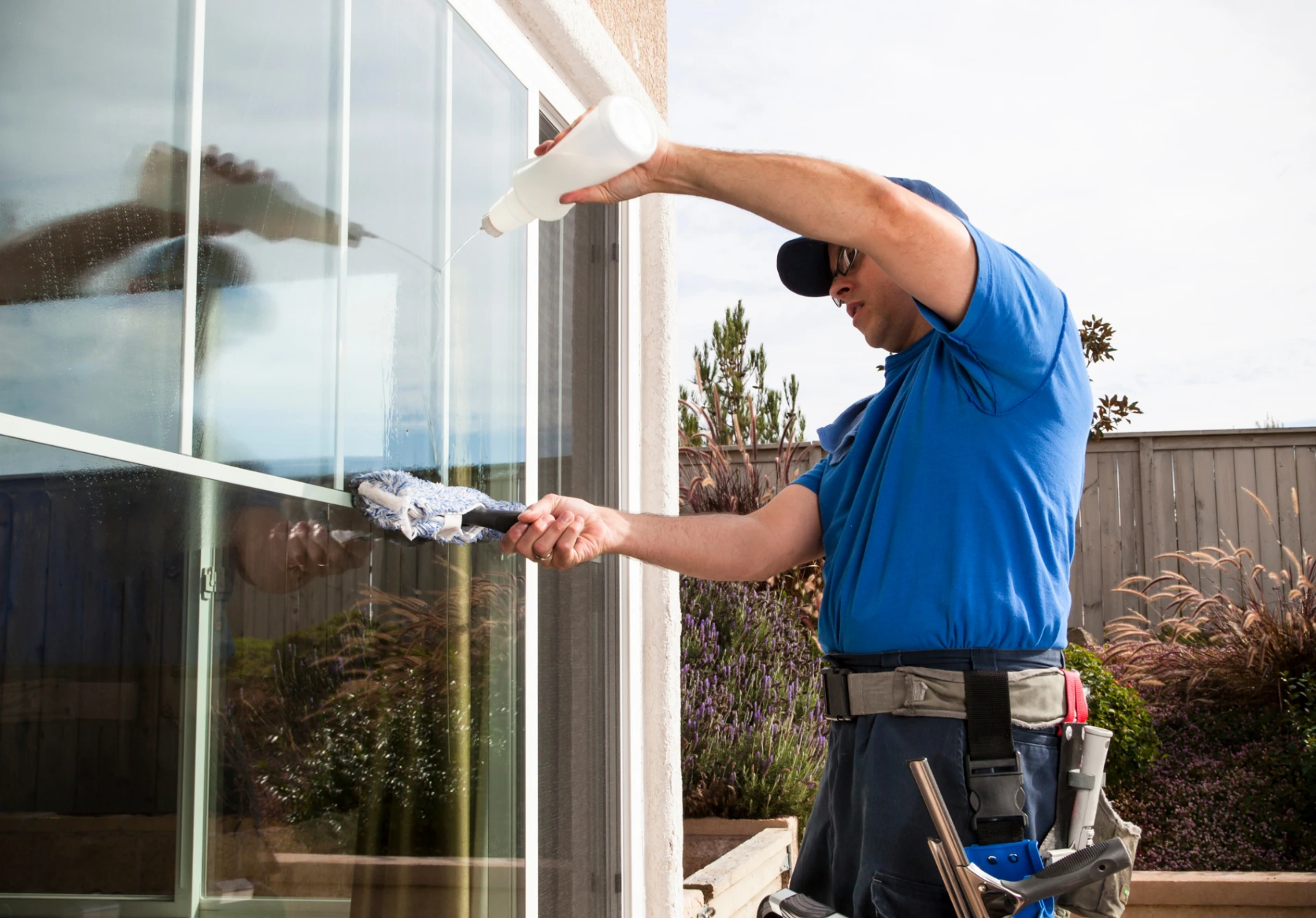 Worker cleaning a window using a cloth and a cleaning solution